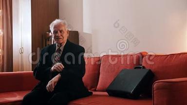 老爷爷——老爷爷正拿着行李箱坐在沙发上，在他的样本上检查时间